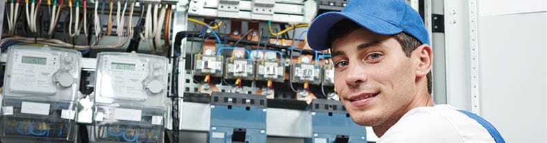 Young adult electrician builder engineer inspecting electric meter and equipment in distribution fuse box